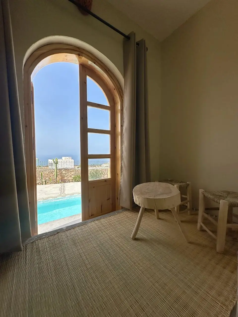 Private room with an arched door opening onto the pool