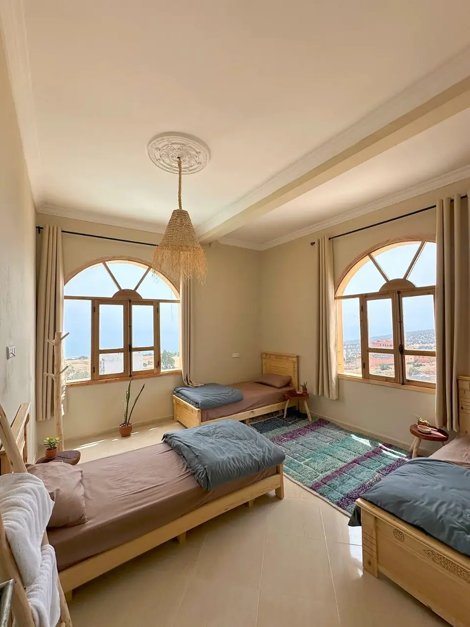 Bright room with three single beds and arched windows